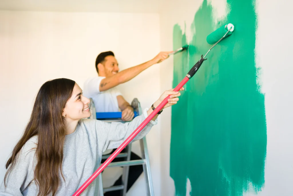 couple painting room wall with green paint 2026 09 22 01 29 53 utc