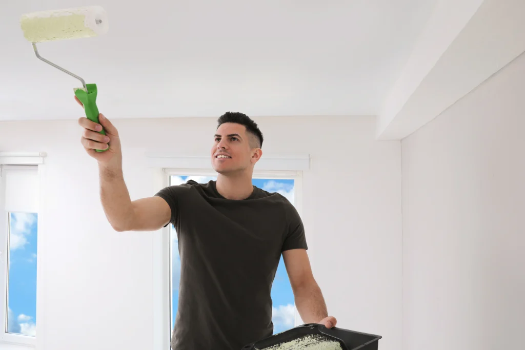 man painting ceiling of white room with roller 2026 09 22 11 54 44 utc