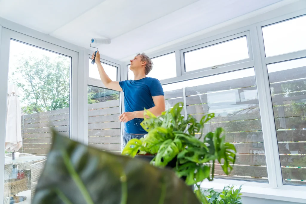 adult man painting ceiling with roller inside home 2026 09 23 19 14 08 utc