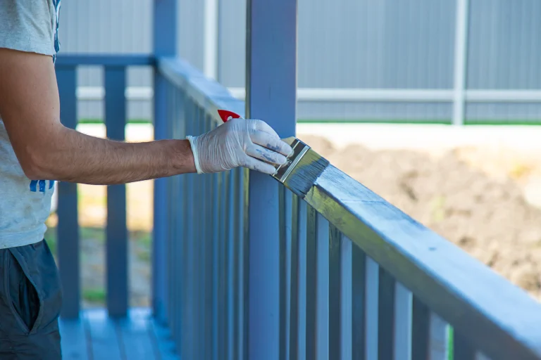 applying protective gray paint to wooden railing 2026 09 21 11 09 57 utc