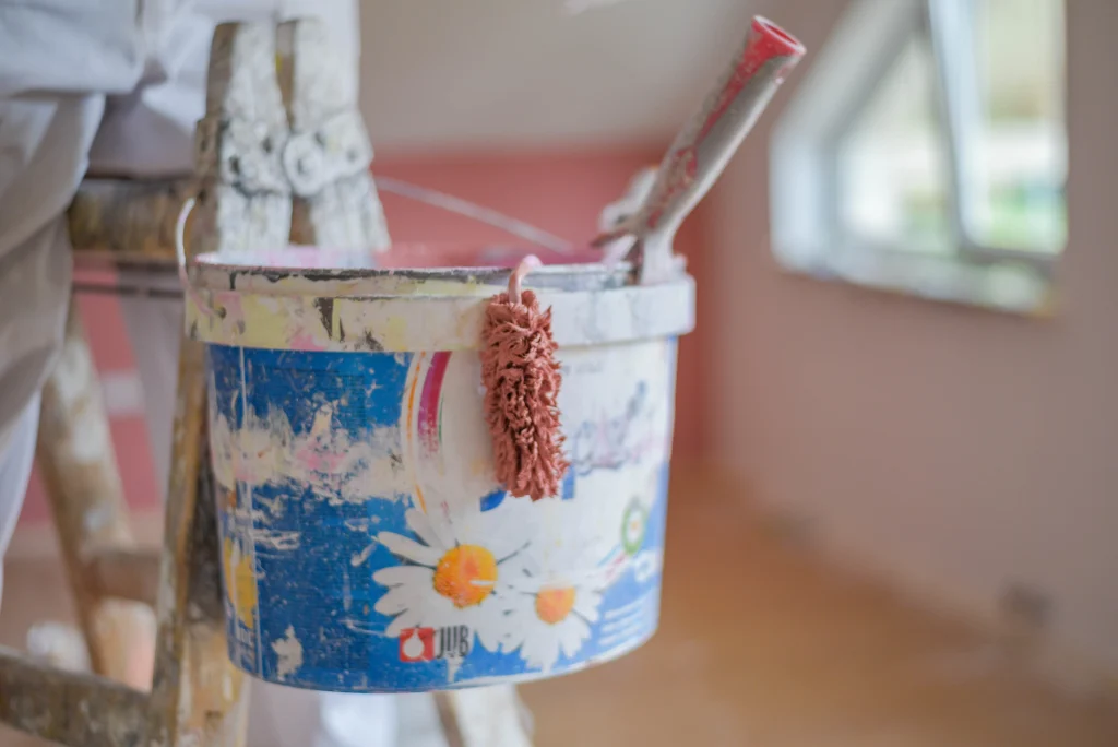 bucket of paint with roller inside a room 2026 09 23 16 41 52 utc