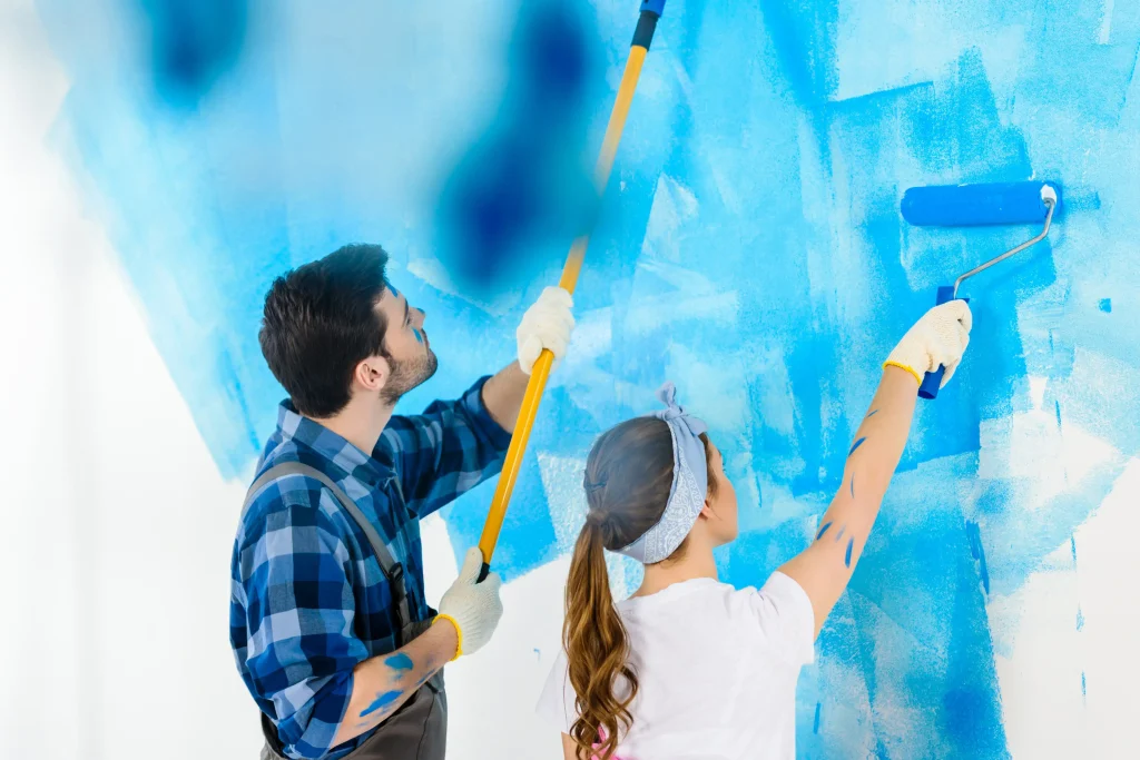couple painting wall bright blue with paint roller 2026 09 22 20 13 19 utc