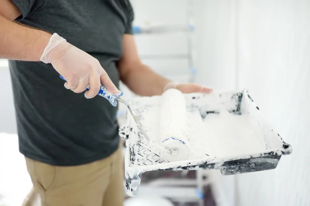 man painting a wall white with paint roller 2026 09 22 03 17 11 utc