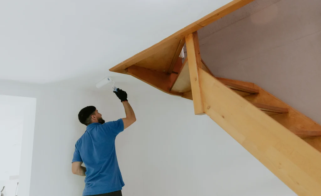 man painting house interior near wooden staircase 2026 09 22 00 22 12 utc