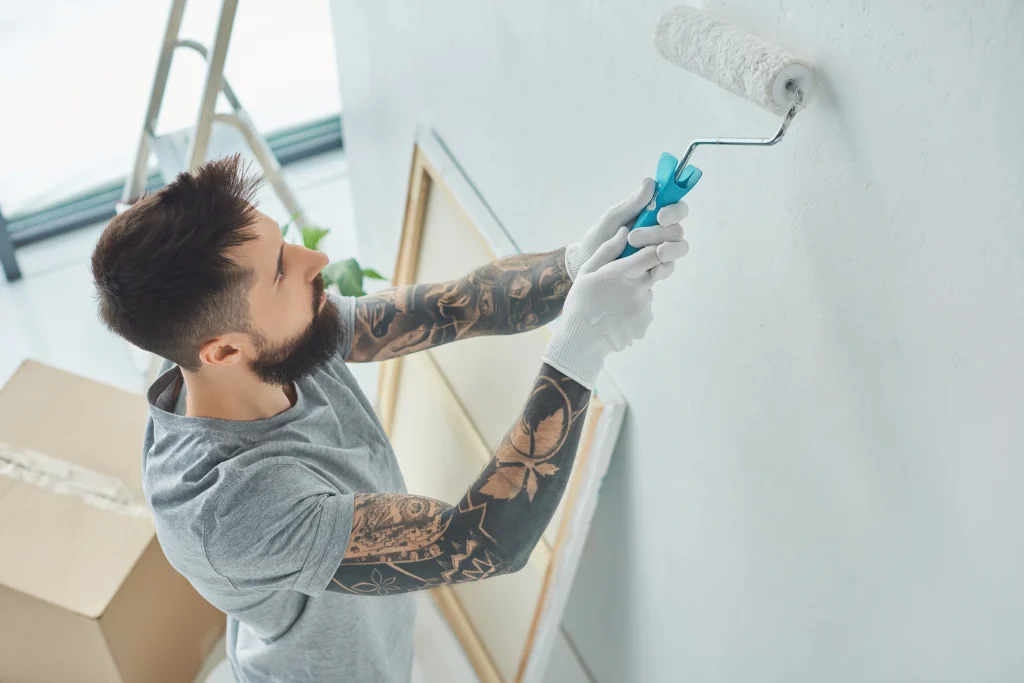 man painting wall with roller indoors home improv 2026 09 21 05 25 55 utc