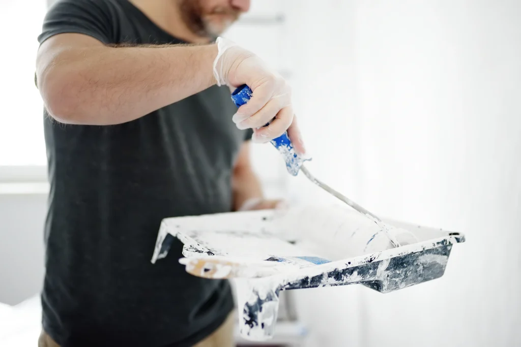 man prepares to paint wall with paint roller 2026 09 21 20 45 41 utc