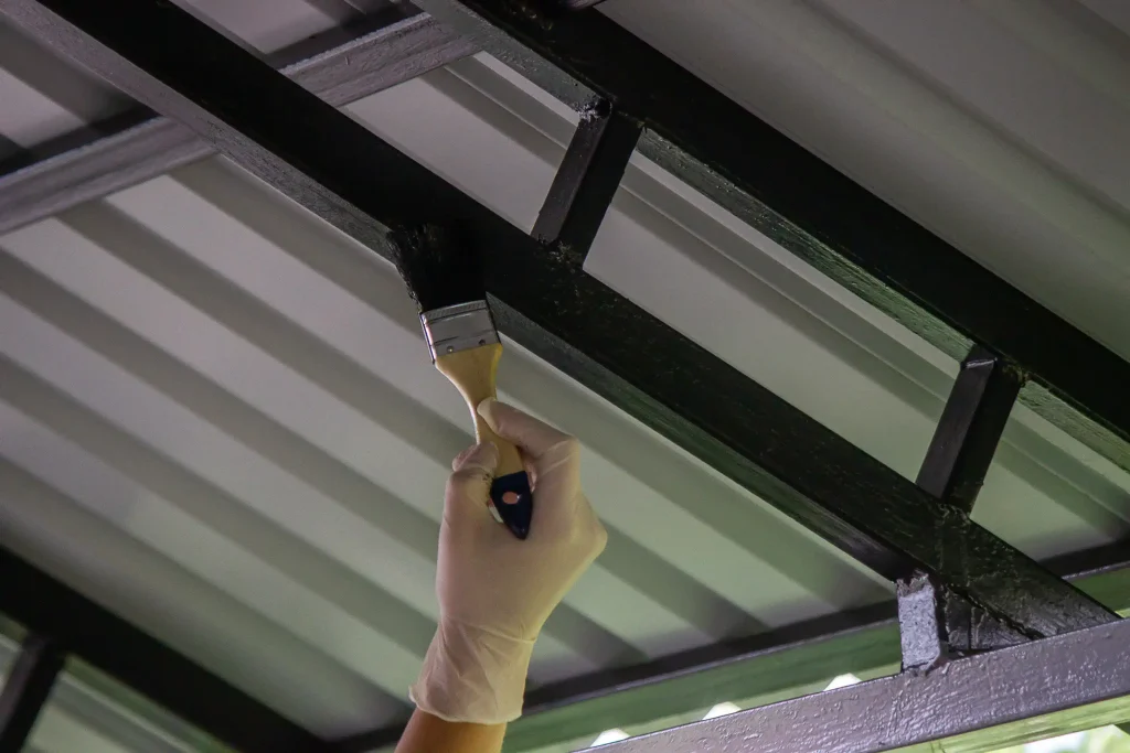 painter applies black paint to metal structure fra 2026 09 23 22 05 57 utc
