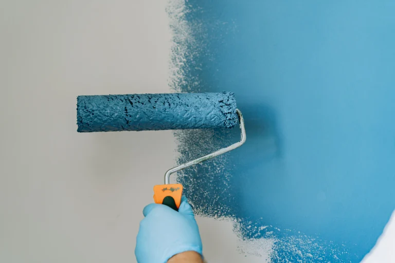 painting roller applying blue paint to white wall 2026 09 21 21 31 28 utc