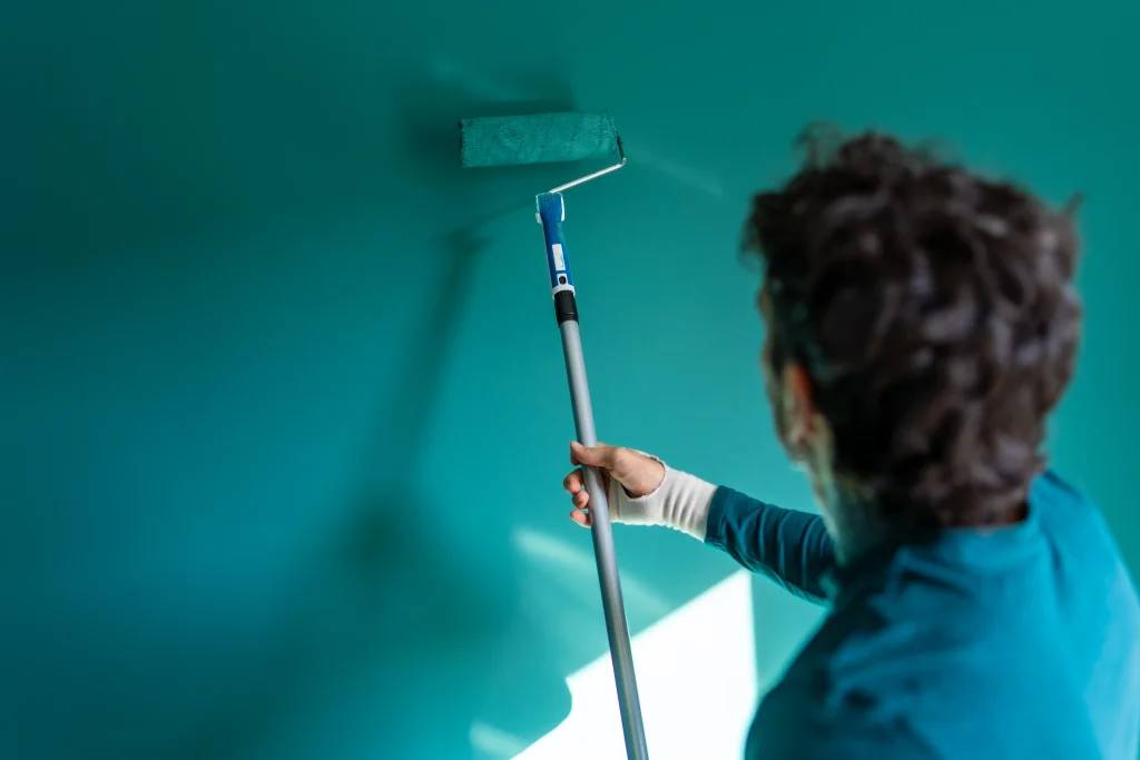 person painting interior wall with vibrant teal ro 2026 09 25 05 33 11 utc
