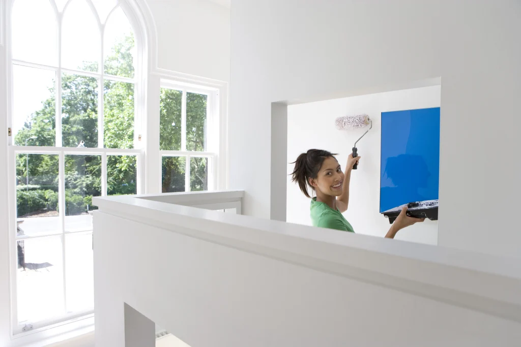 woman painting a wall blue in bright room 2026 09 22 08 44 19 utc