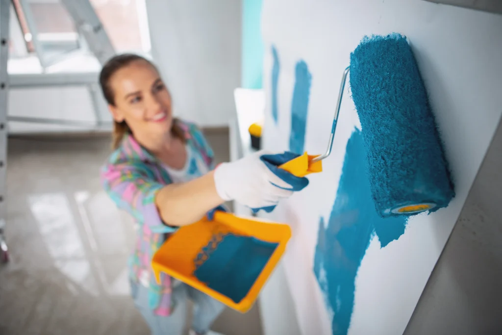woman painting wall with blue paint in home 2026 09 25 02 40 58 utc