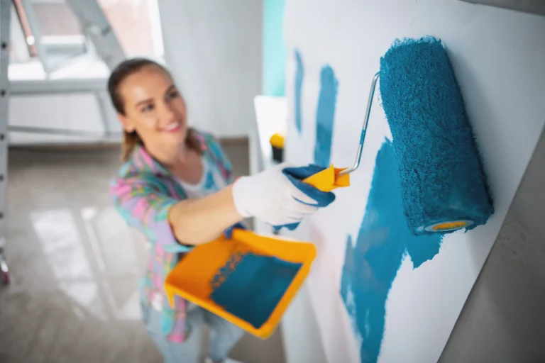 woman painting wall with blue paint in home 2026 09 25 02 40 58 utc