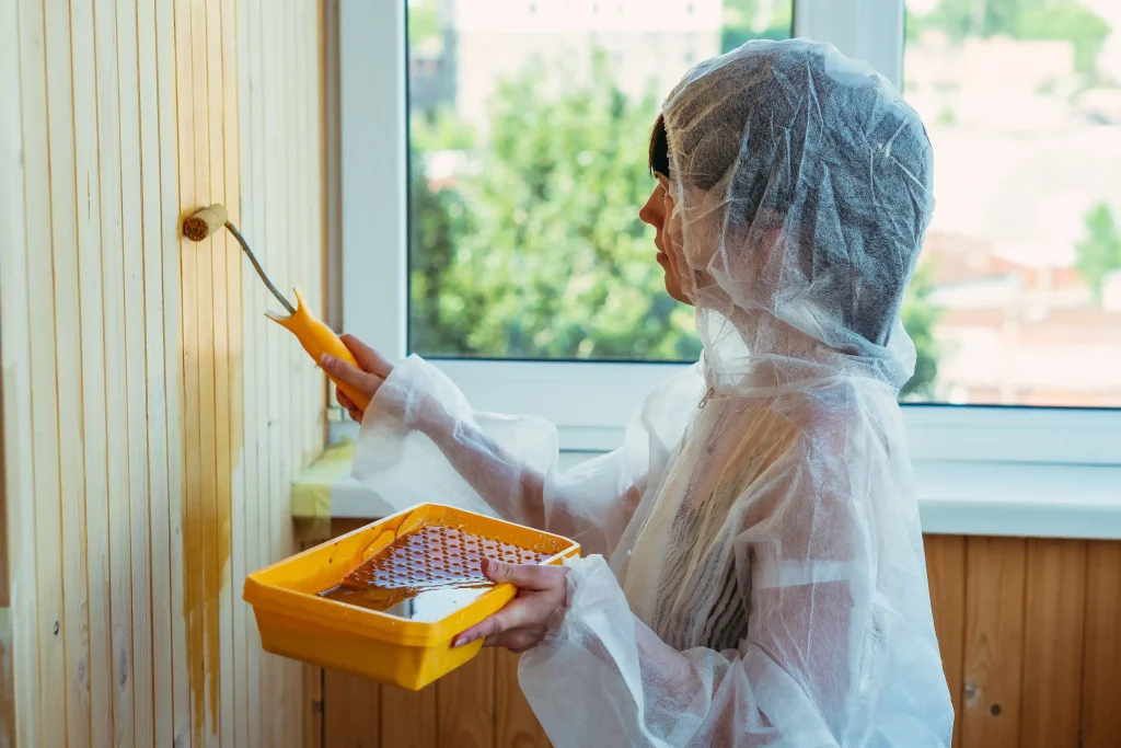 woman paints wall in protective clothing indoors 2026 09 25 02 52 52 utc
